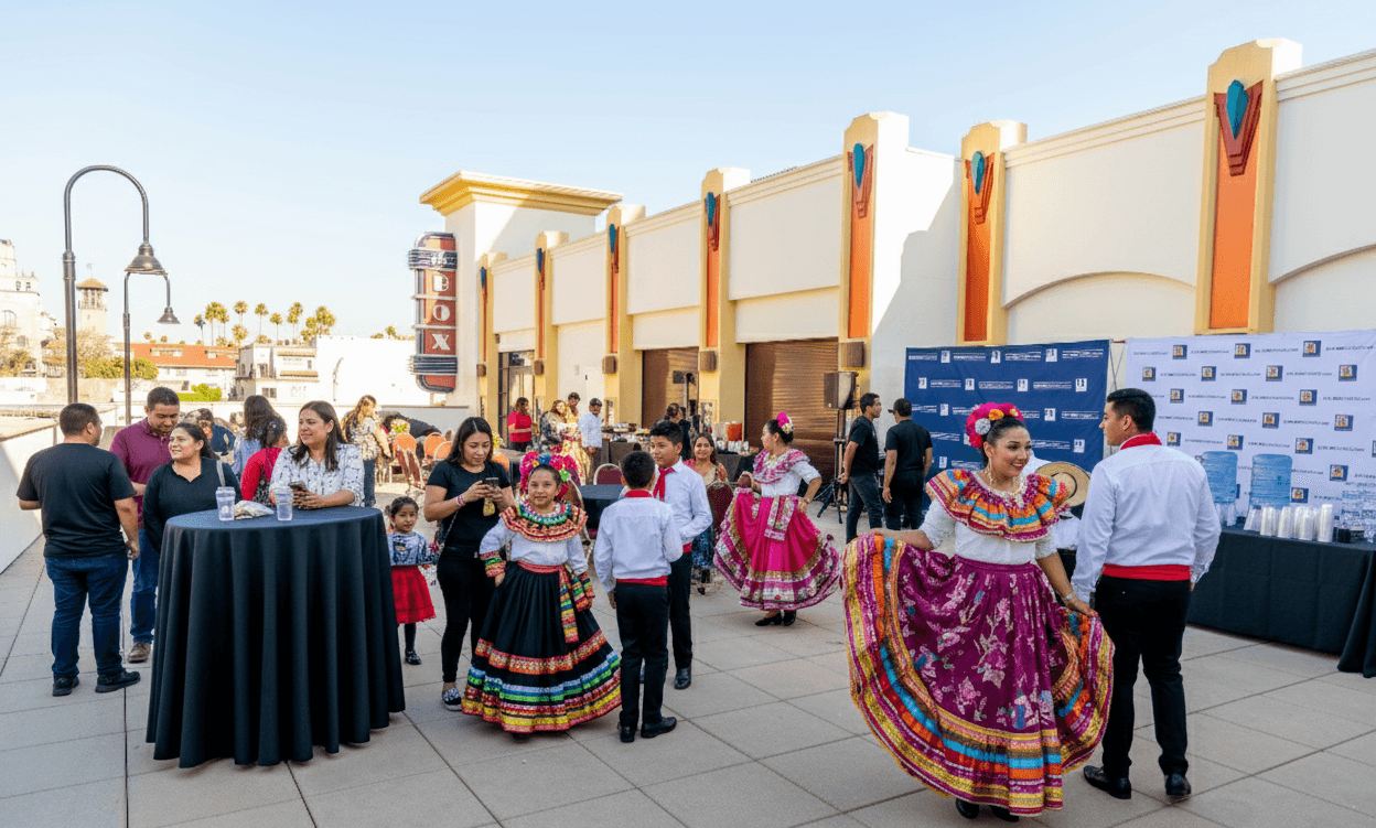 Sponsors networking with folklórico performers during the rooftop reception